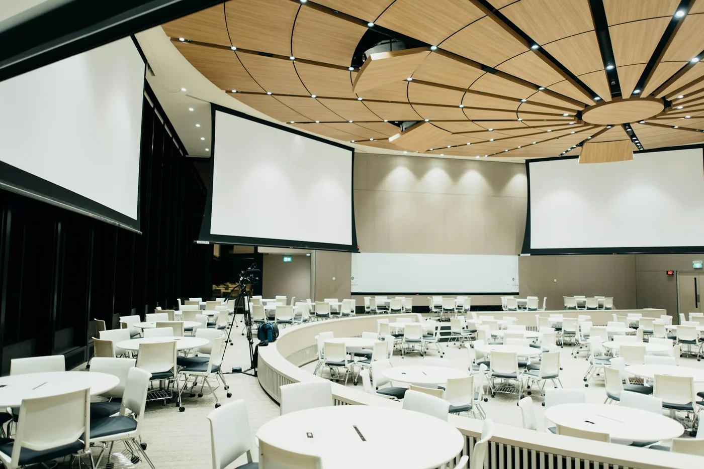 Evenementenzaal in dineropstelling met ronde tafels en witte stoelen